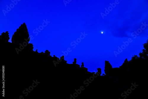 Silhouette of angkorian lion features on stairs leading to Bakong Temple, Roluos Group, Angkor Park, Siem Reap, Cambodia against moonlight. photo