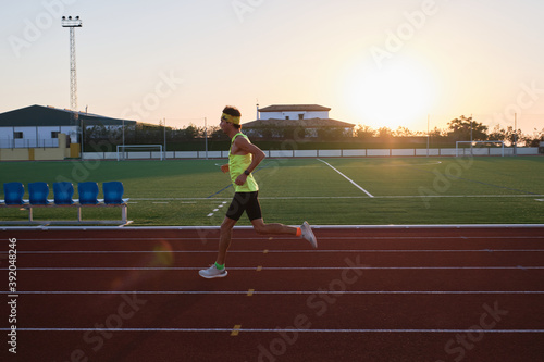 young man trains running on new and red tracks photo