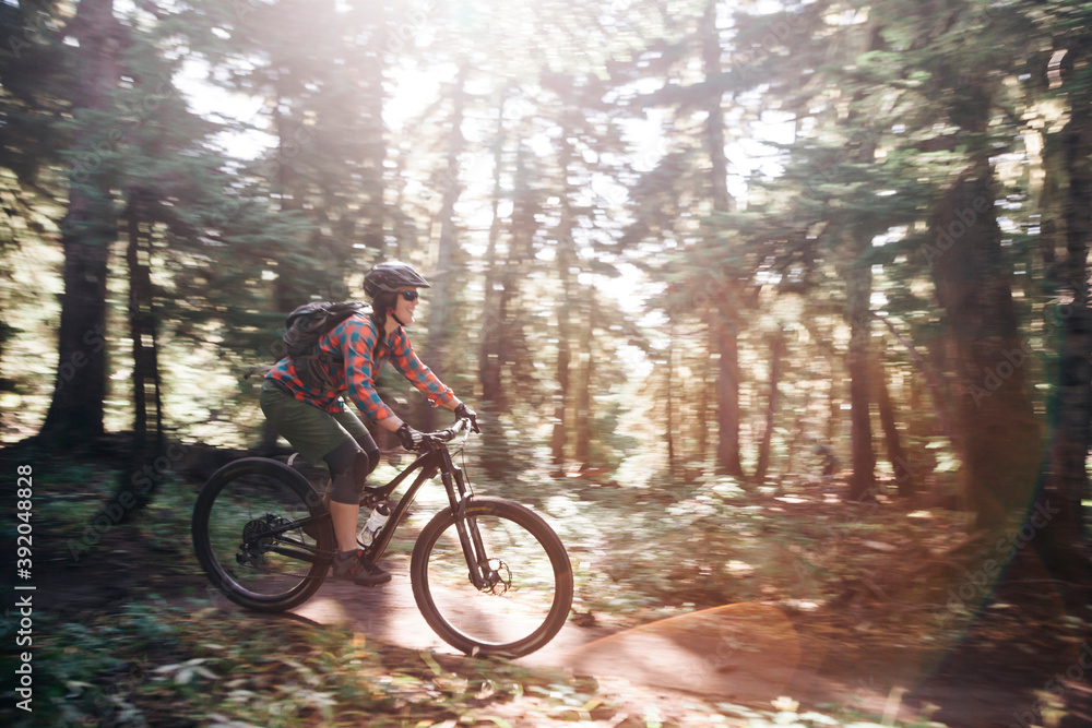 A young woman rides her bike on a sunny day at Mt. Hood, Oregon. A young woman rides her bike on a sunny day at Mt. Hood, Oregon.