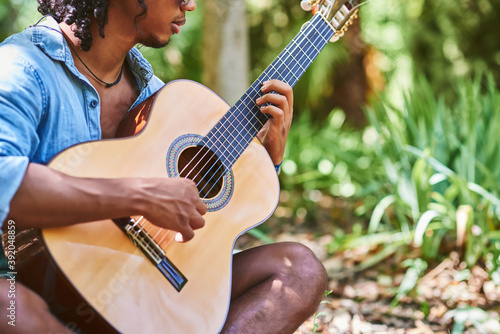 Musician practicing with the guitar in the field. photo
