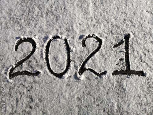 Inscription on the snow 2021. Concept background, texture of snow. New year