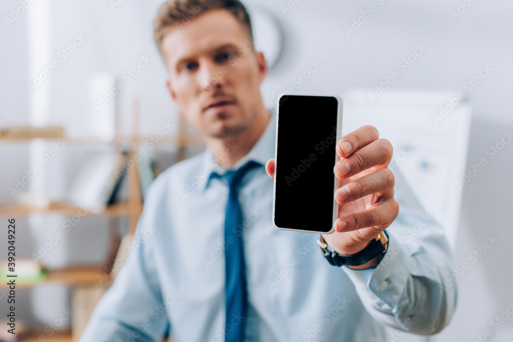 Smartphone with blank screen in hand of businessman on blurred background Smartphone with blank screen in hand of businessman on blurred background