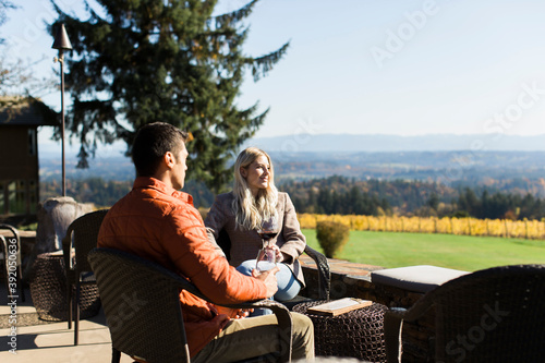 A young couple sits on a patio at a winery in Oregon. photo