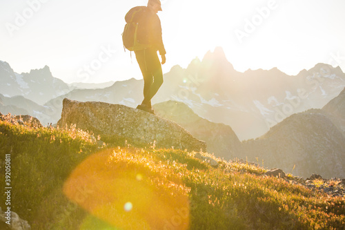 Side view of hiker backpacking across a high mountain range. photo