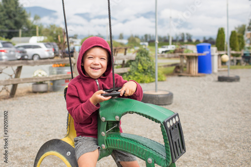 boy sits on play ride on tractor at farm made from recycled tires