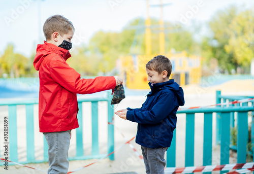 little boy handing a mask to his brother photo