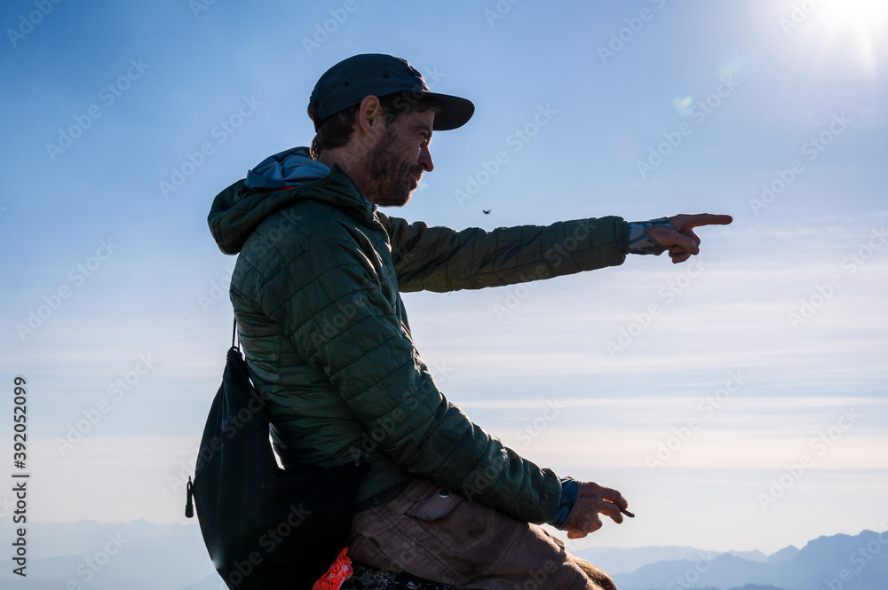 Male hiker pointing on the summit in the north cascades Male hiker pointing on the summit in the north cascades
