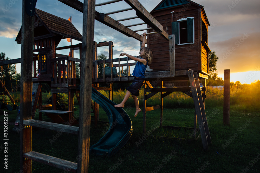 Young boy on play center at sunset Young boy on play center at sunset