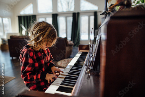 Little boy with messy hair playing the piano photo