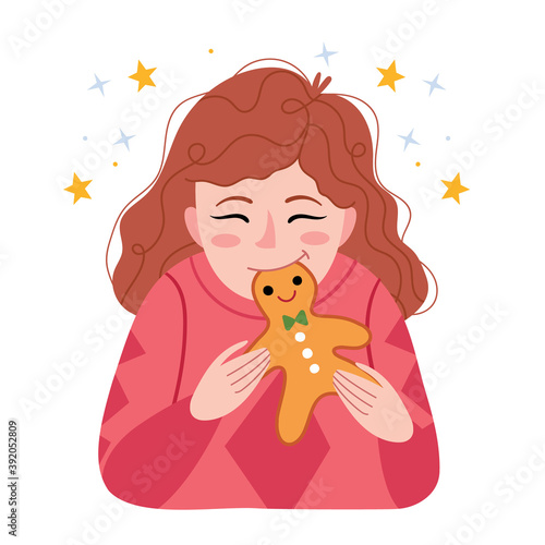 Red-haired girl eats a gingerbread man. Winter mood.Funny happy child biting and eating healthy bread, outdoors. Hungry kid.