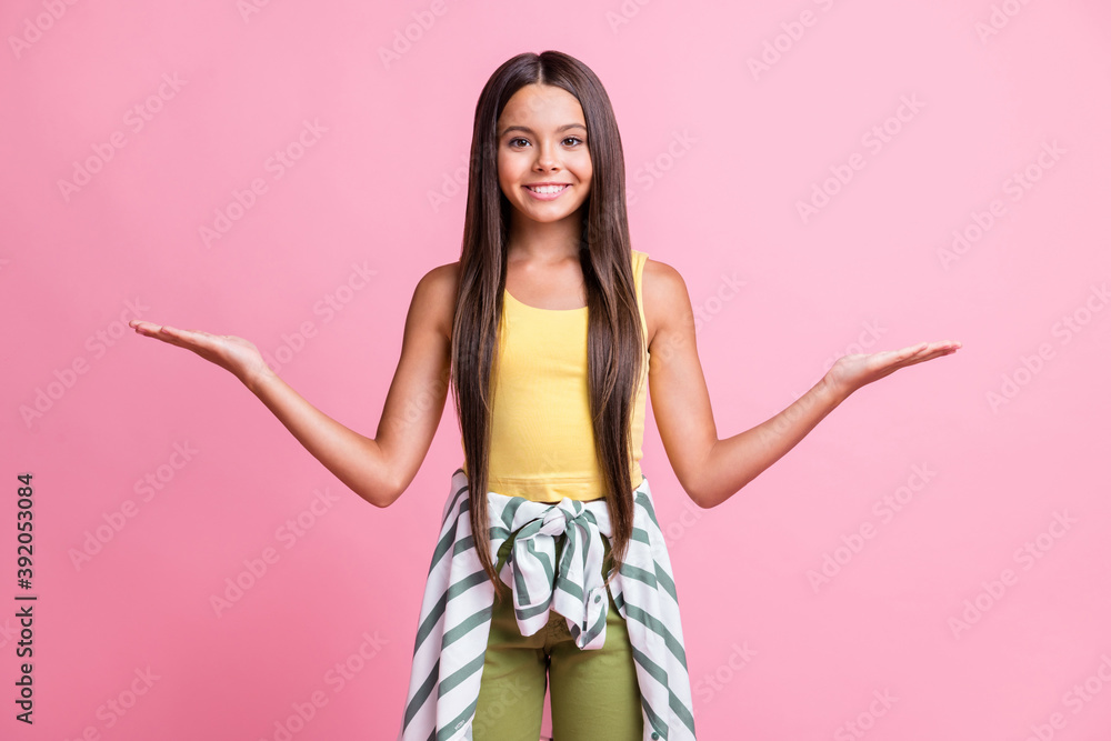 Photo of lovely little girl show empty place two palms beaming smile isolated on pink color background Photo of lovely little girl show empty place two palms beaming smile isolated on pink color background