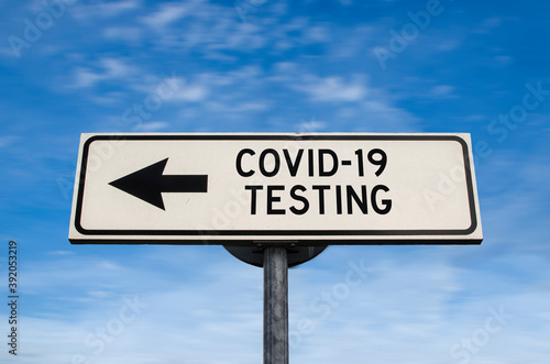 COVID-19 testing road sign, arrow on blue sky background. One way blank road sign with copy space. Arrow on a pole pointing in one direction.