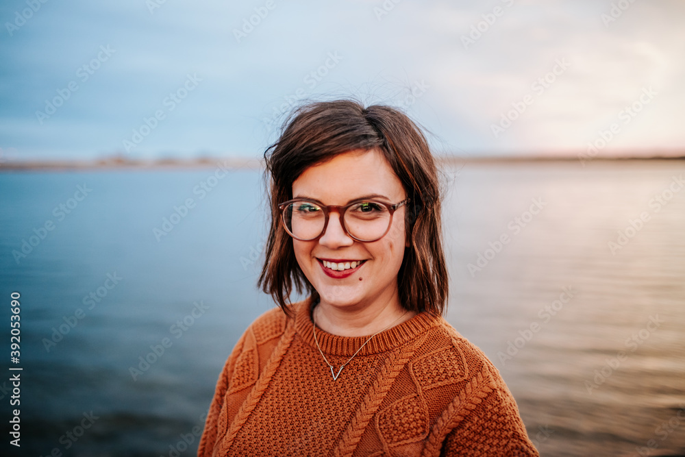 Center Portrait of a woman wearing glasses near a lake Center Portrait of a woman wearing glasses near a lake