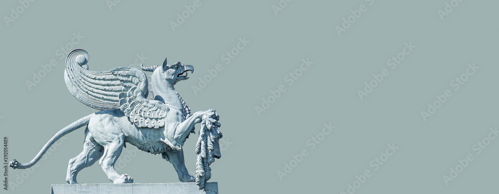 Fototapeta premium Banner with an old statue of medieval griffin, a hybrid of lion and bird, on the top of the State Opera House in downtown of Dresden, Germany, details, isolated at solid background and copy space