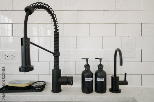 Kitchen sink with black fixtures and soap