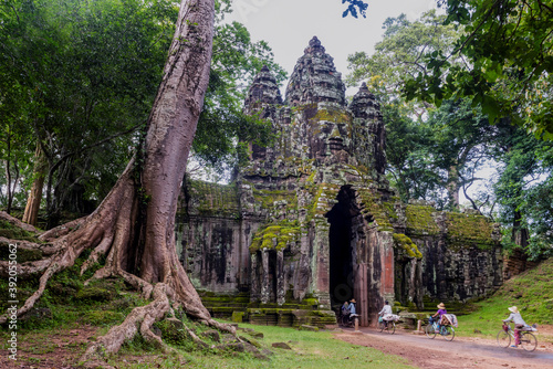 Angkor Archaeological Park, Siem Reap, Cambodia. Locals cycle home through north gate of Angkor Thom.