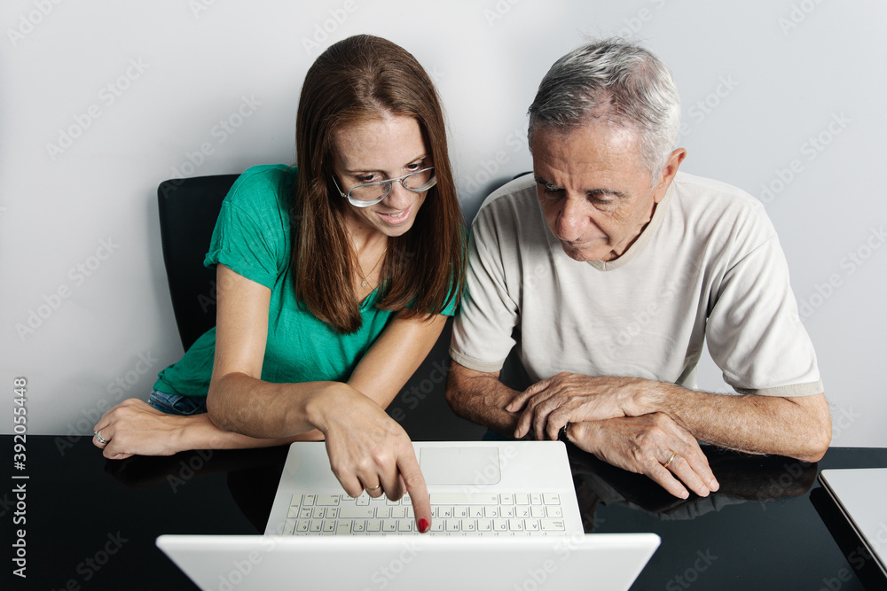 Woman helping father with laptop Woman helping father with laptop