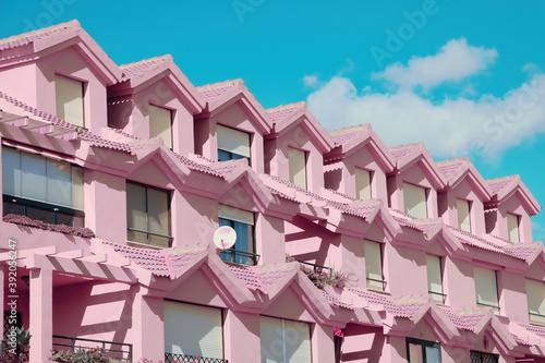 Row of houses in a bizarre pink color in a residential neighborhood.