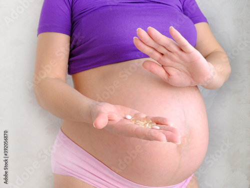 Wallpaper Mural pills in the hand of a pregnant woman, with the other hand she shows rejection, health care Torontodigital.ca
