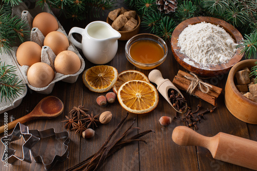 Culinary background for homemade Christmas baking. Fresh and healthy ingredients for gingerbread dough on a wooden background.