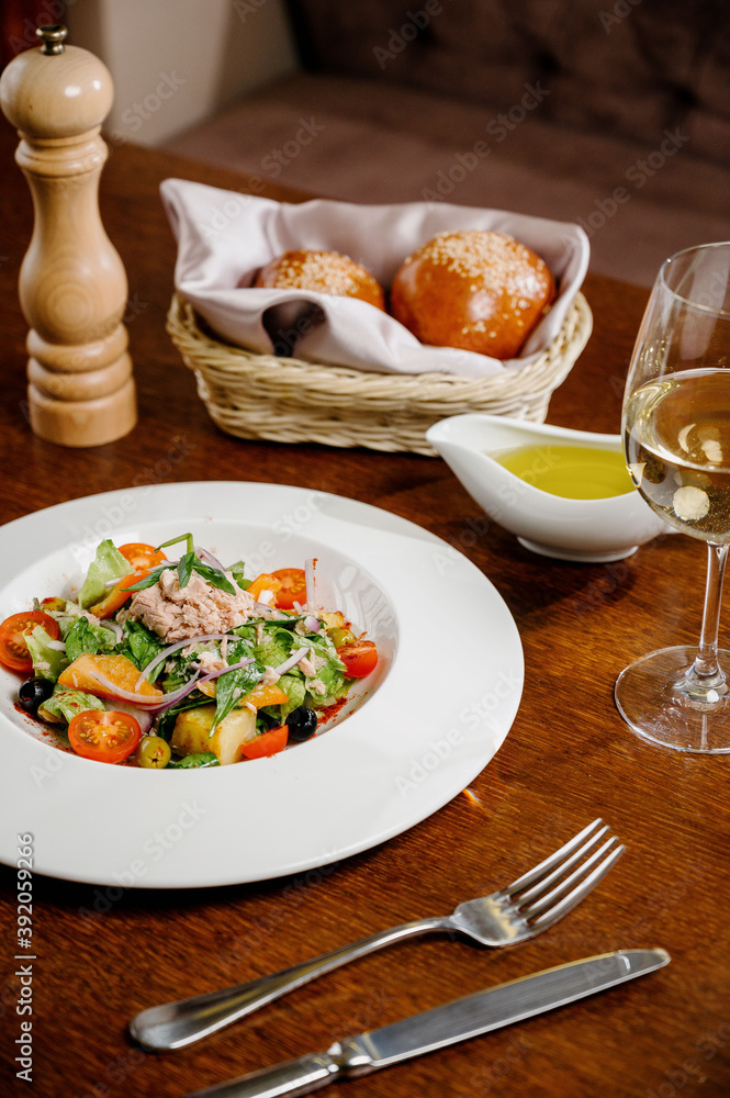 Caesar salad with croutons, quail eggs, cherry tomatoes and grilled chicken in wooden table