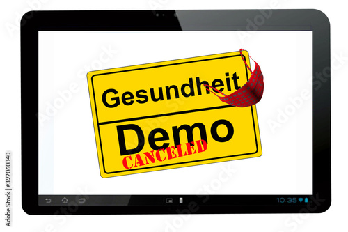 Tablet PC mit Ortschild isoliert auf weiß Demo canceled kontra Gesundheit photo