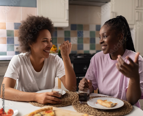 Delighted black women speaking during sleepover photo