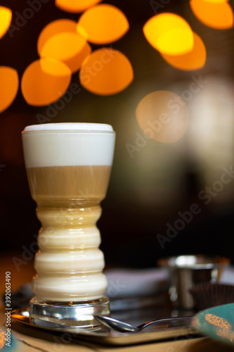 Glass cup with latte on a background of blurry bokeh lights