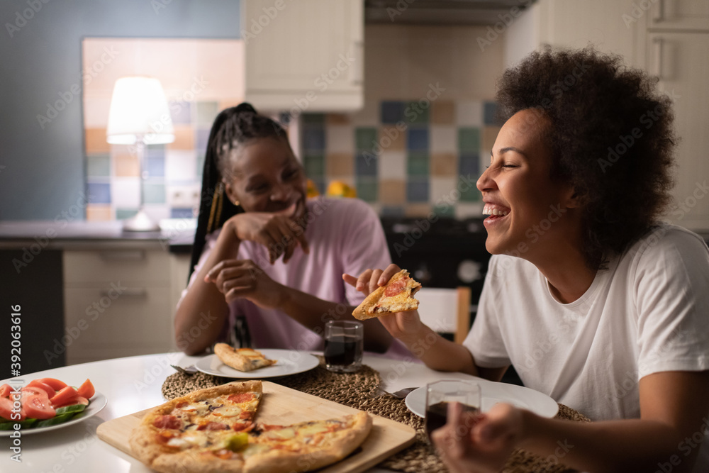 Mixed race woman laughing at joke near friend Mixed race woman laughing at joke near friend