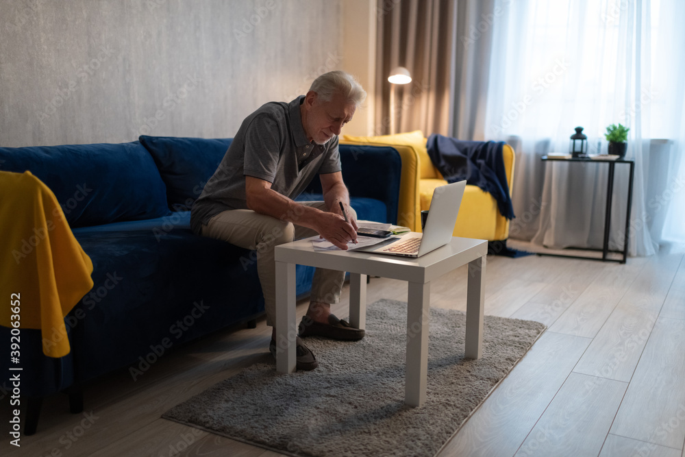 Senior man checking bills at home Senior man checking bills at home