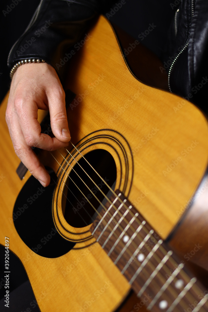 Fototapeta premium hand of a man playing acoustic guitar close up