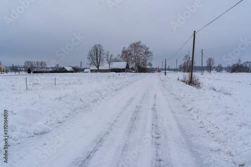 Slippery Countryside Road, Snow Covered Ground on Cloudy Winter Day - Moody Scene