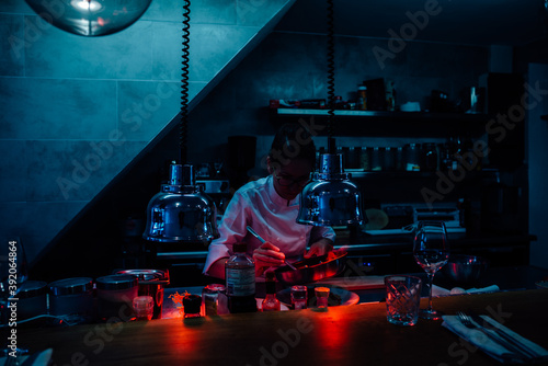 Chef decorating food in restaurant kitchen using infrared lamps photo