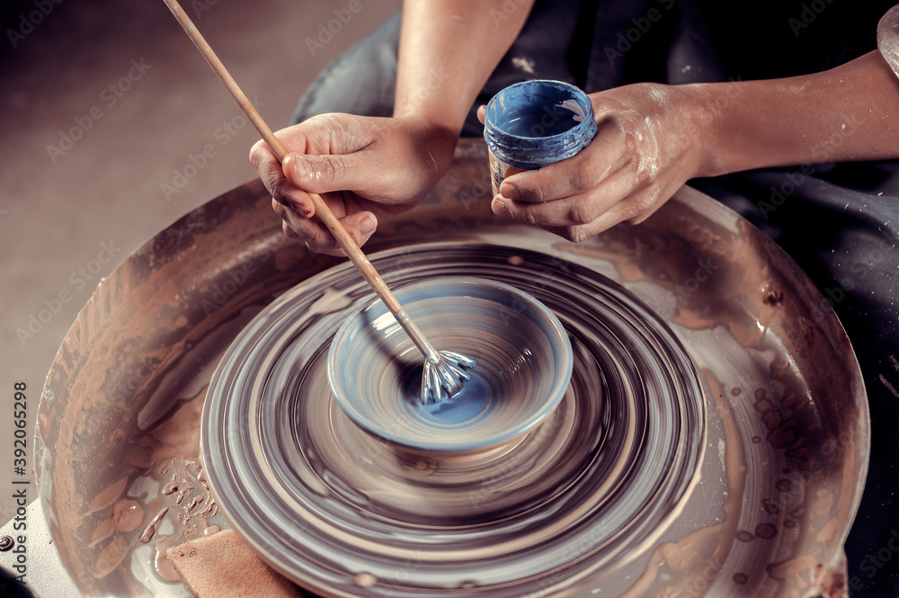 Fototapeta premium Ceramist girl posing while making earthenware. Handmade. Close-up.