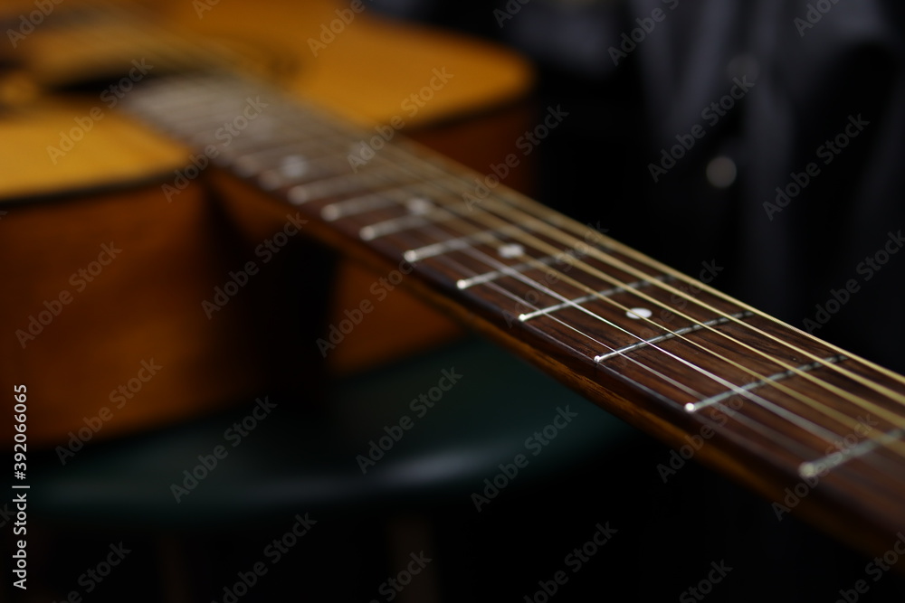 Fototapeta premium Classic wooden acoustic guitar closeup, on a black background, rock, country music concept