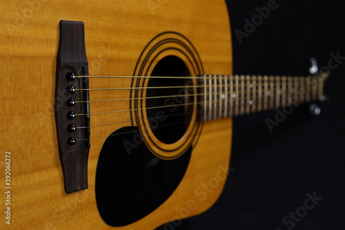 Classic wooden acoustic guitar closeup, on a black background, rock, country music concept