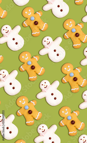 Fototapeta Naklejka Na Ścianę i Meble -  Vertical christmas cookies pattern in the shape of a snowman and a gingerbread man decorated with icing sugar and fondant on a green background