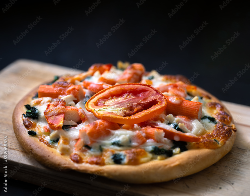 Homemade pizza and tomato topping. isolated on dark background Homemade pizza and tomato topping. isolated on dark background