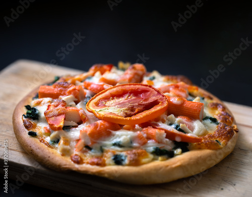 Homemade pizza and tomato topping. isolated on dark background