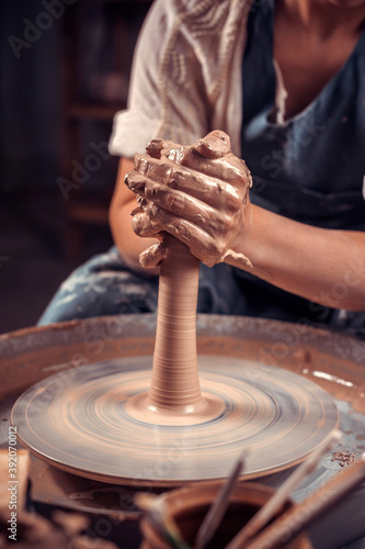 production process of pottery. Forming a clay teapot on a potter's wheel. photo