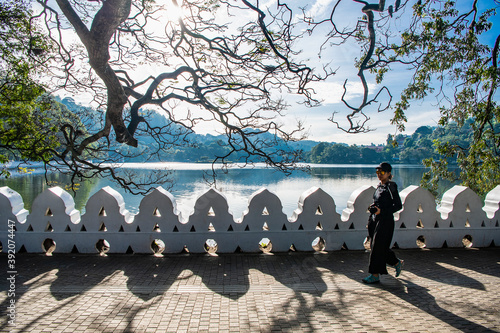 Woman walking along lake Kandy in Sri Lanka