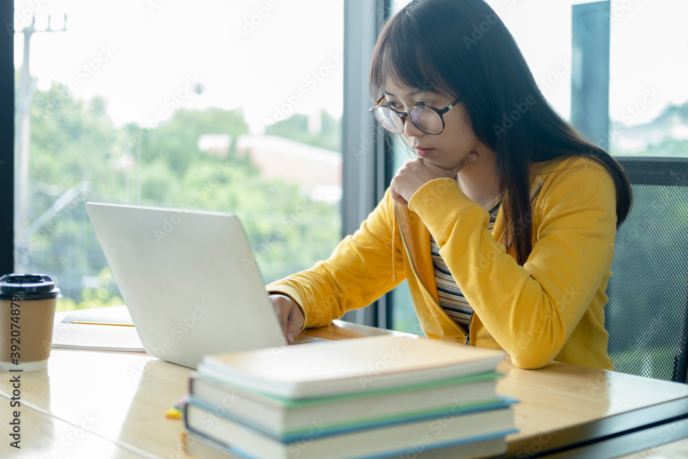 Young collage student using computer and mobile device studying Young collage student using computer and mobile device studying