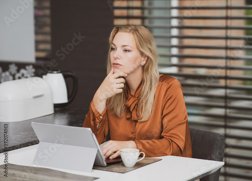Schreibarbeiten mit IT Ger  ten in der Firma oder im Heimb  ro  attraktive Frau arbeitet am Tablet-PC - Symbolfoto.