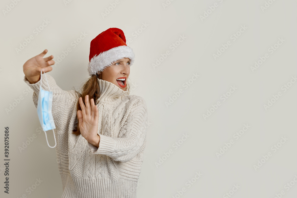 The portrait of a beautiful woman wearing a Santa hat refusing the protection mask COVID-19 Pandemic Life The portrait of a beautiful woman wearing a Santa hat refusing the protection mask COVID-19 Pandemic Life