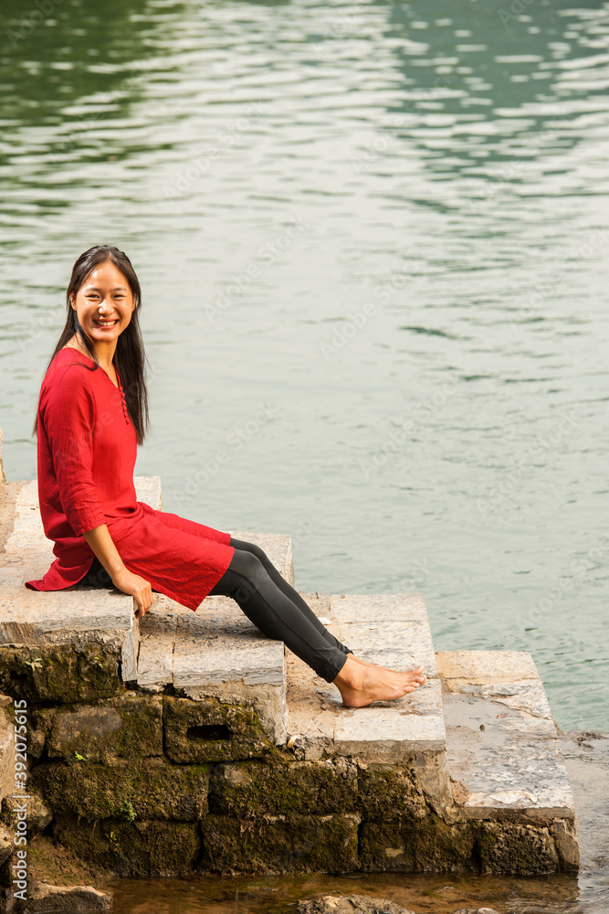 beautiful woman sitting next to the river Li in Yangshuo