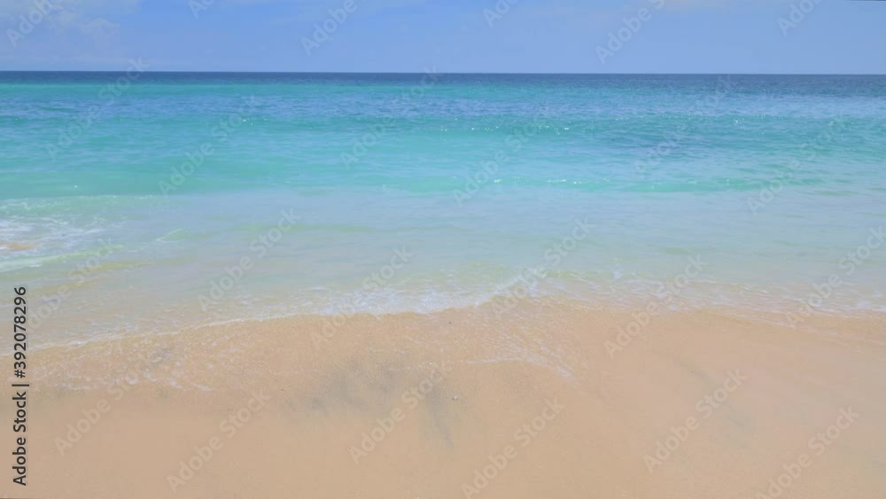 Tropical beach with big waves are hitting sand with white foam and splashes in sunny day Tropical beach with big waves are hitting sand with white foam and splashes in sunny day