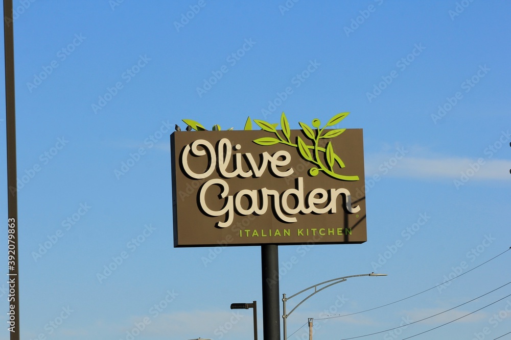 Olive Garden Advertisement sign on a black pole with a blue sky and
