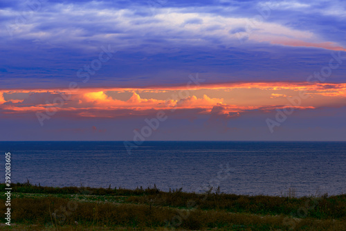 Black sea coast, evening seascape with dense clouds and bright colorful break in the clouds