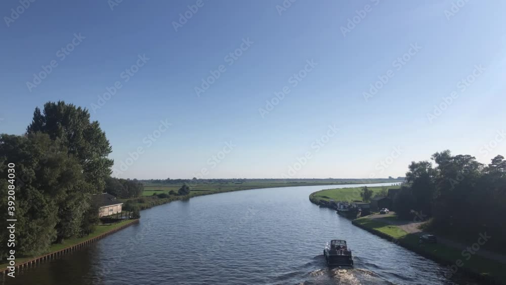 Canal with a boat around Warten in Friesland, The Netherlands Canal with a boat around Warten in Friesland, The Netherlands