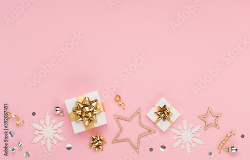 Christmas card - gold and silver decorations, festive gifts, snowflakes on pink background. Xmas, winter, new year concept. © Iuliia Metkalova